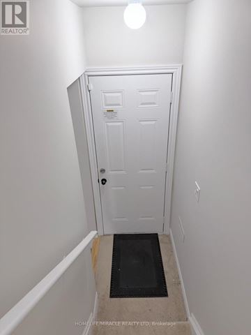 Oshawa (Kedron) apartment for rent - A brick house with a brown door and a window.