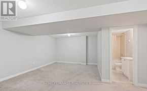 Oshawa (Kedron) apartment for rent - A spacious, empty room with a carpeted floor and white walls.