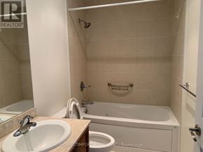 Barrie (City Centre) condo for rent - A bathroom with a tub, sink, and toilet.