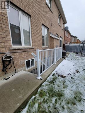 Mississauga (Churchill Meadows) apartment for rent - A brick house with a white fence and a hose on the ground.