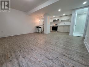 Mississauga (Churchill Meadows) apartment for rent - A spacious room with wooden flooring and white walls.