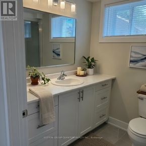 Burlington (Appleby) apartment for rent - A bathroom with a white toilet, sink, and cabinets.