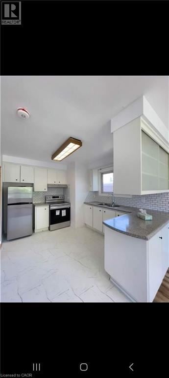 Hamilton apartment for rent - A modern kitchen with white cabinets and a marble countertop.