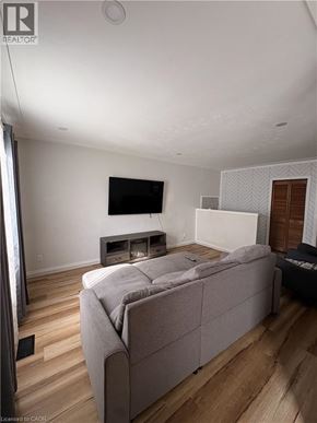Hamilton apartment for rent - A room with wooden floors and a white ceiling with a light fixture.