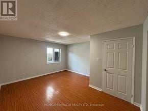 Toronto (Kennedy Park) townhouse for rent - A room with a wooden floor and a white door.