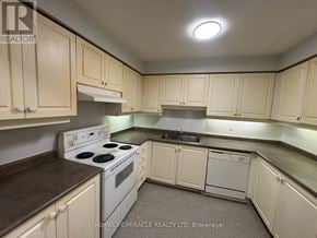 Toronto (Kennedy Park) townhouse for rent - A kitchen with white cabinets and a stove top oven.