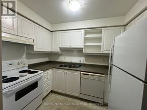 Toronto (Kennedy Park) townhouse for rent - A kitchen with white cabinets and appliances.