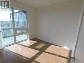 Toronto (Thorncliffe Park) condo for rent - A room with a wooden floor and a sliding glass door.