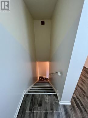 Toronto (Hillcrest Village) townhouse for rent - A long hallway with wooden floors and white walls.