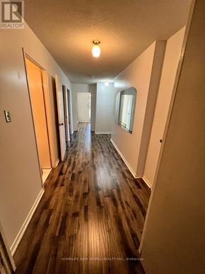 Toronto (Hillcrest Village) townhouse for rent - A long hallway with wood floors and white walls.