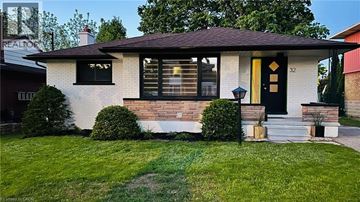 Kitchener apartment for rent - House number 32 has a yellow door and a brick chimney.