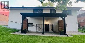Kitchener apartment for rent - A white house with a black gate and a black roof.