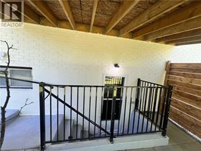Kitchener apartment for rent - A balcony with a black railing and a small tree.
