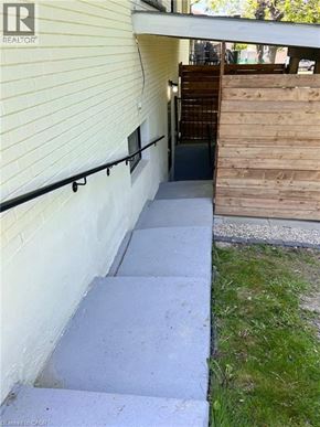 Kitchener apartment for rent - A set of concrete stairs leading to a wooden deck outside a house.