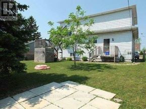 Thorold (Thorold Downtown) triplex for rent - A white house with a tree in front of it.