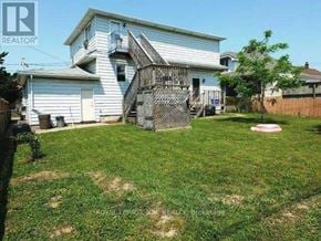 Thorold (Thorold Downtown) triplex for rent - A house with a white exterior and a green lawn.