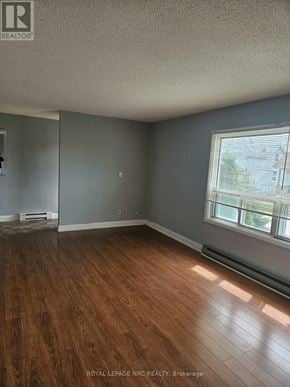 Thorold (Thorold Downtown) triplex for rent - A room with wooden flooring and a window letting in sunlight.