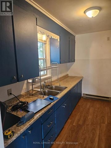 Thorold (Thorold Downtown) triplex for rent - A kitchen with dark blue cabinets and a granite countertop.
