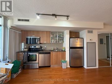 Toronto (Bay Street Corridor) condo for rent - A kitchen with wooden cabinets and stainless steel appliances.