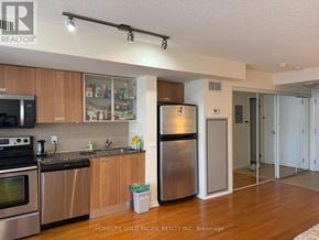 Toronto (Bay Street Corridor) condo for rent - A kitchen with wooden cabinets and stainless steel appliances.