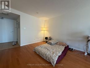 Toronto (Bay Street Corridor) condo for rent - A bedroom with a bed, lamp, and a door.