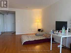 Toronto (Bay Street Corridor) condo for rent - A bedroom with a bed, a desk, and a lamp.