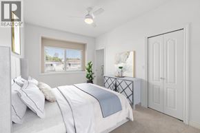 Vancouver apartment for rent - A bedroom with a large bed and a window overlooking a building.
