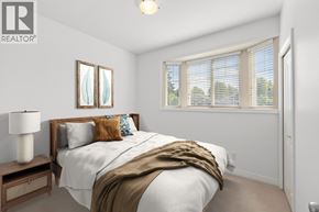 Vancouver apartment for rent - A bedroom with a bed, nightstand, and window with blinds.