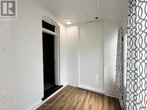 St. Thomas fourplex for rent - A white room with a wooden floor and a patterned wallpaper on the right side.