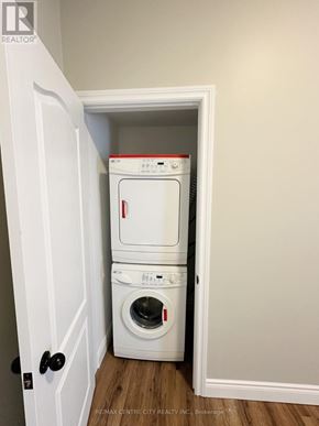St. Thomas fourplex for rent - A white dryer and washer are stacked in a small closet.