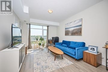Hamilton (Lakeshore) condo for rent - A living room with a blue couch and a television.
