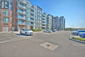 Hamilton (Lakeshore) condo for rent - A white car is parked in a parking lot in front of a multi-story apartment building.