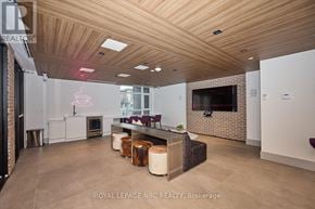 Hamilton (Lakeshore) condo for rent - A modern living room with a fireplace and a flat screen TV.