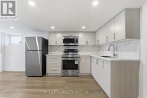 Oshawa (Vanier) multi-family for rent - A modern kitchen with a refrigerator, microwave, and oven.