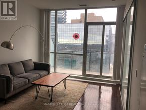 Toronto (Bay Street Corridor) condo for rent - A living room with a grey couch and a wooden coffee table.