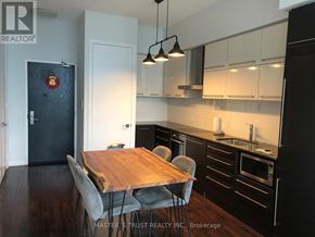 Toronto (Bay Street Corridor) condo for rent - A kitchen with a wooden table and chairs.