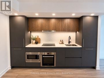 Toronto (North St. James Town) condo for rent - A modern kitchen with dark brown cabinets and stainless steel appliances.