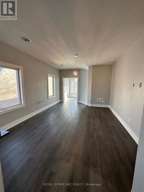 Welland (Welland Downtown) duplex for rent - A room with wooden flooring and white walls.