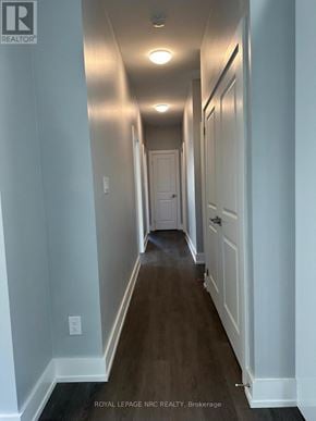 Welland (Welland Downtown) duplex for rent - A long hallway with white walls and wood floors.