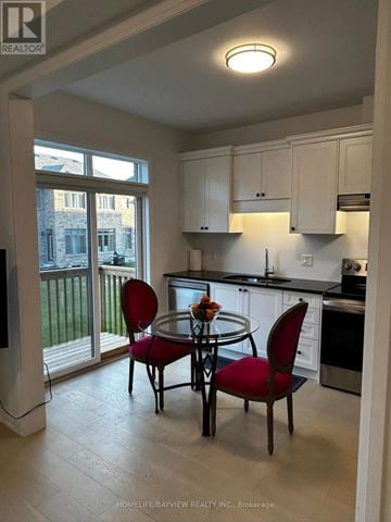 Barrie (Painswick South) apartment for rent - A kitchen with a table and chairs in front of a window.
