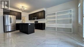 Markham (Berczy) apartment for rent - A modern kitchen with a refrigerator, cabinets, and a countertop.