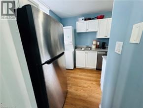 Hamilton condo for rent - A kitchen with a black fridge and white cabinets.