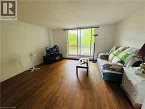 Hamilton condo for rent - A living room with a couch, a coffee table, and a fan.