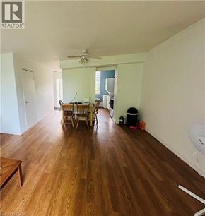 Hamilton condo for rent - A room with wooden floors and a dining table with chairs.