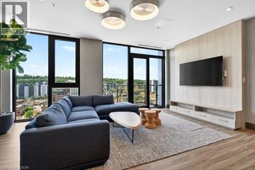 Hamilton condo for rent - A modern living room with a large grey sofa and a flat screen TV.