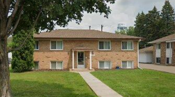 North Saint Paul apartment for rent - A two-story brick house with a white door and windows.