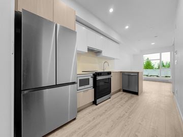 Surrey apartment for rent - A modern kitchen with a stainless steel refrigerator and wooden flooring.