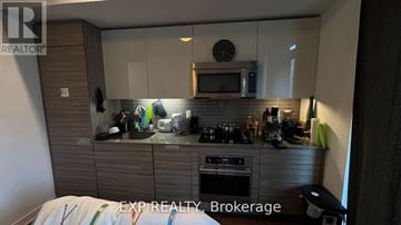 Toronto (University) condo for rent - A kitchen with a microwave, oven, and sink.