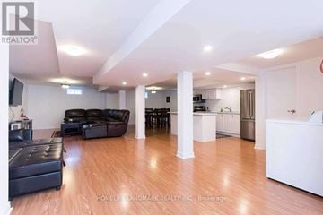Whitchurch-Stouffville apartment for rent - A living room with a black leather couch and a wooden floor.
