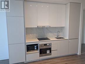 Vaughan (Vaughan Corporate Centre) condo for rent - A kitchen with white cabinets and a marble countertop.